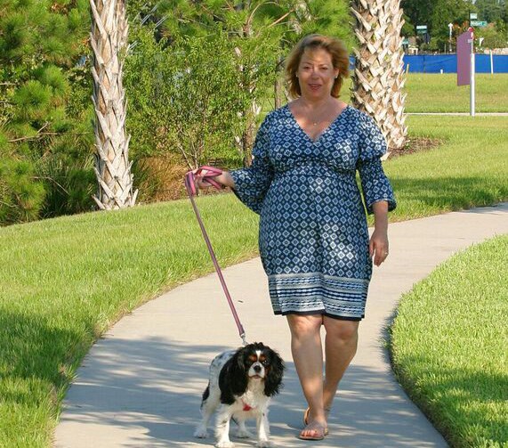 Woman walking along a trail with her dog.