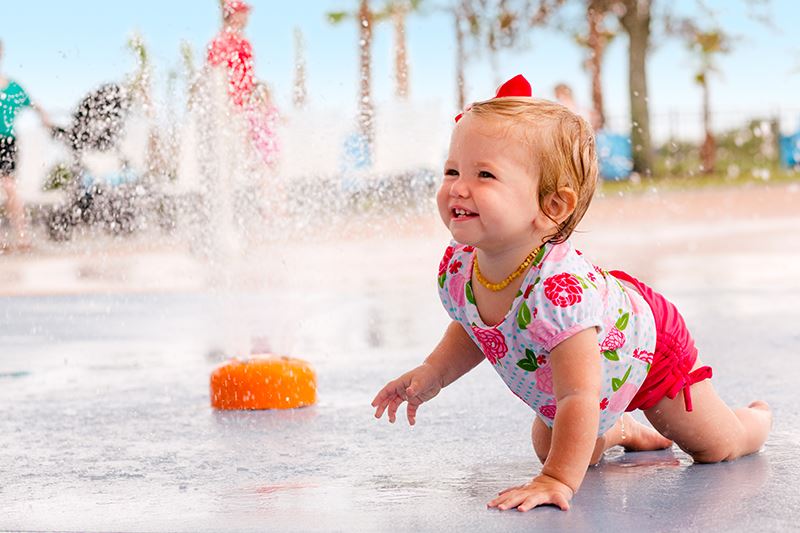 Toddler in splash pad area in Waterset.