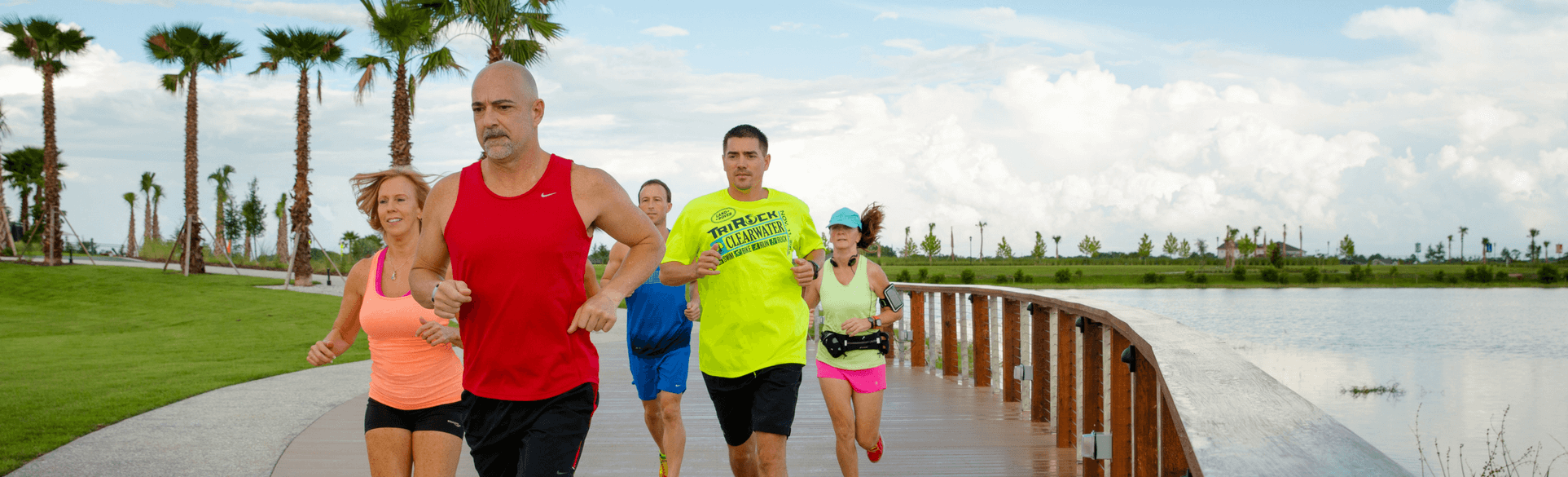 People running on a lakeside trail in Waterset