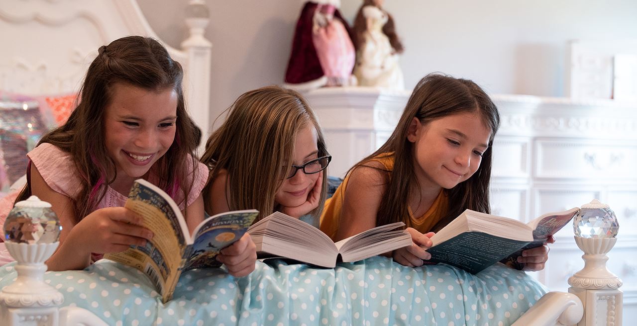 Girls enjoying reading books together in Waterset.