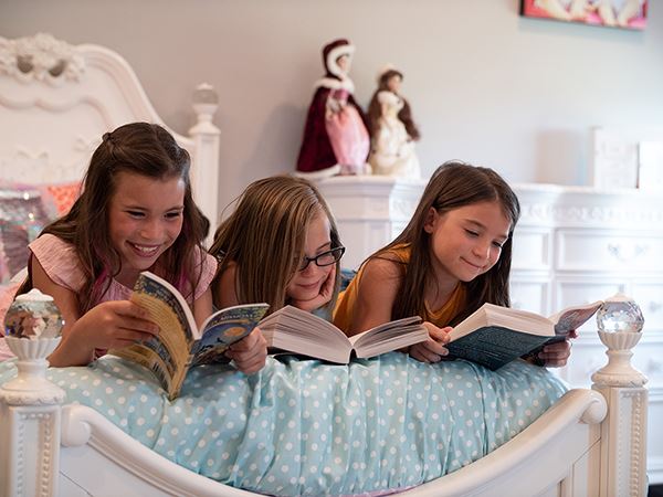 Triplets enjoying reading books together.