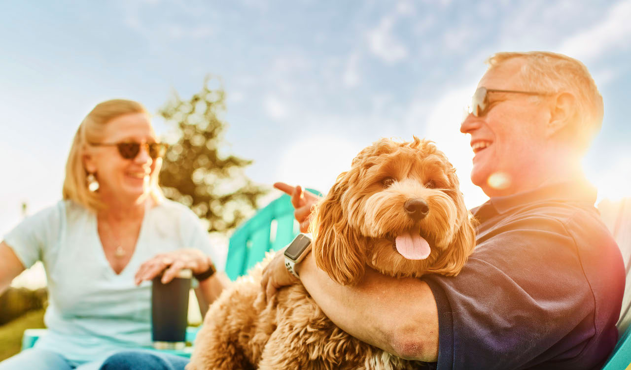 Active adult couple with puppy at Waterset dog park.